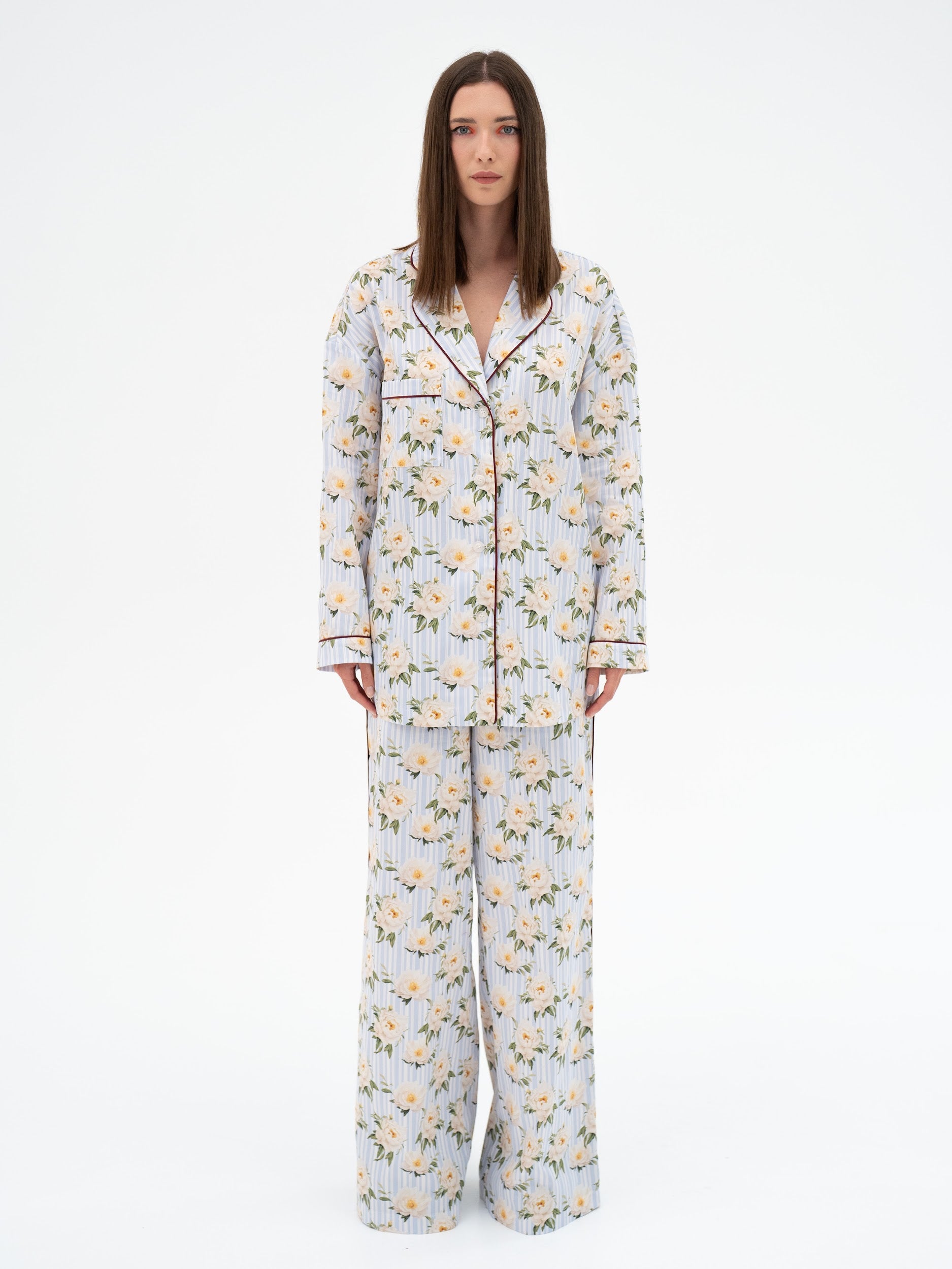Woman wearing a floral pajama set on a white background